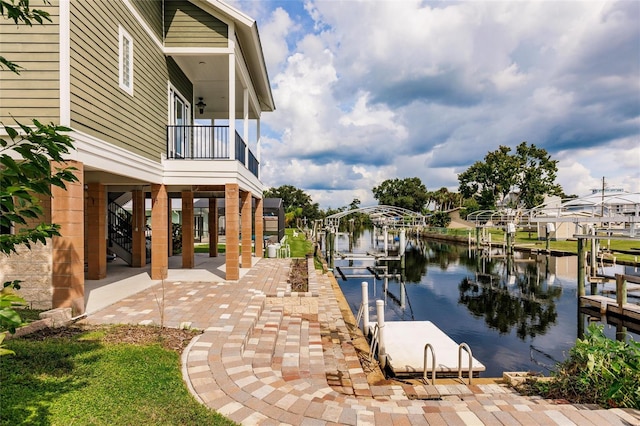 dock area featuring a water view, boat lift, a patio area, and stairway