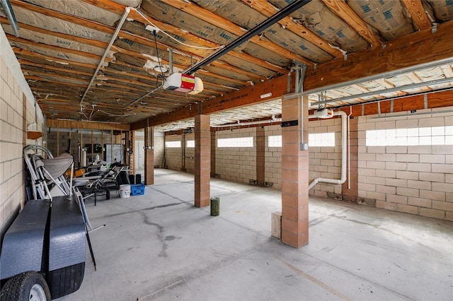 garage featuring concrete block wall and a garage door opener