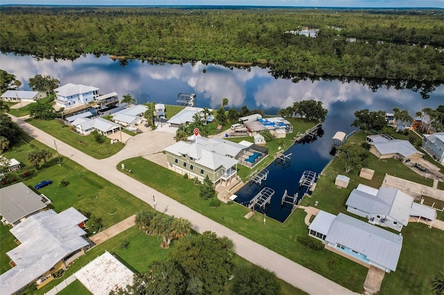 drone / aerial view featuring a forest view, a residential view, and a water view