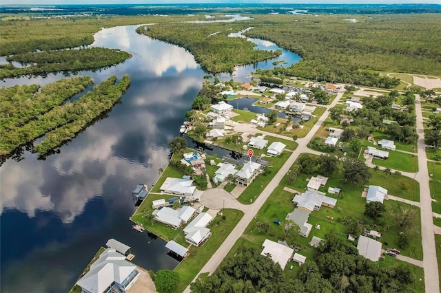drone / aerial view featuring a water view, a wooded view, and a residential view