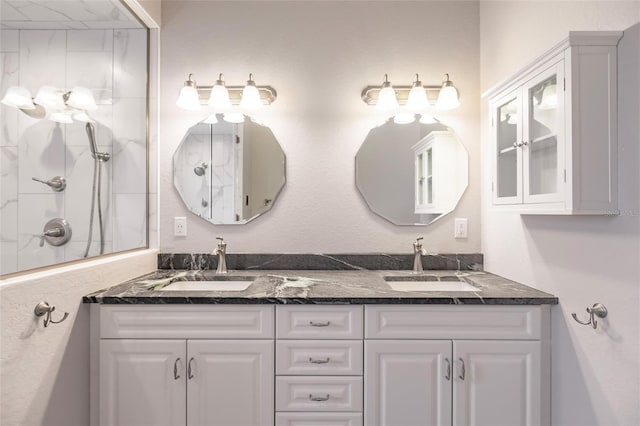 full bath with a shower, double vanity, and a sink