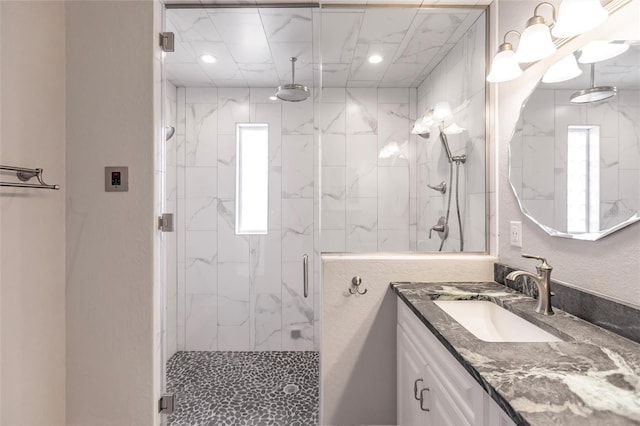 full bath with a marble finish shower, recessed lighting, and vanity