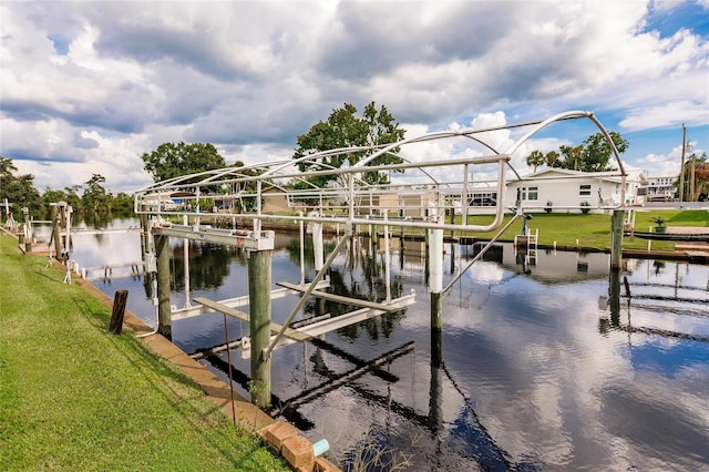 view of dock with a water view and a yard