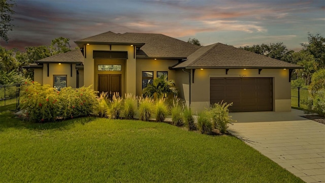 prairie-style home with a lawn and a garage