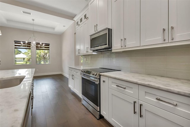 kitchen featuring appliances with stainless steel finishes, sink, white cabinetry, and light stone countertops