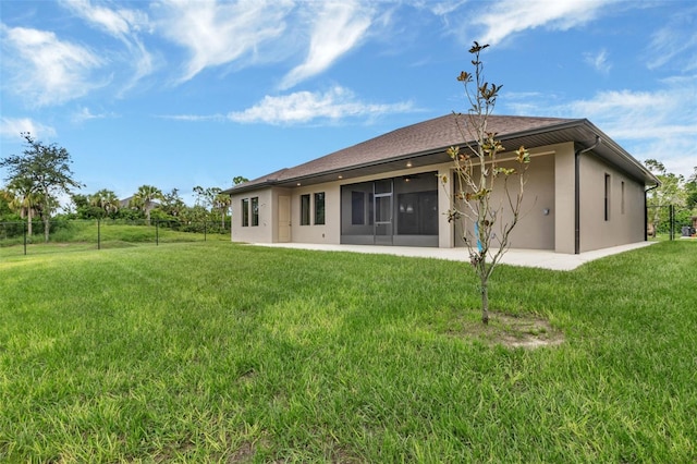 back of house featuring a yard, a sunroom, and a patio