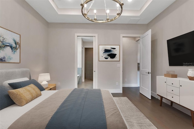 bedroom featuring a raised ceiling, dark wood-type flooring, and a chandelier