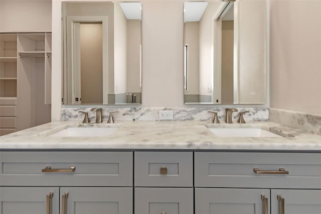 full bathroom with a sink and double vanity