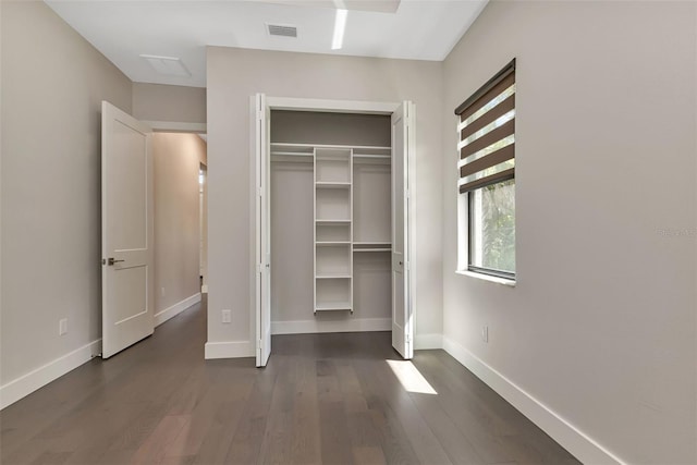 unfurnished bedroom featuring dark wood finished floors, visible vents, and baseboards