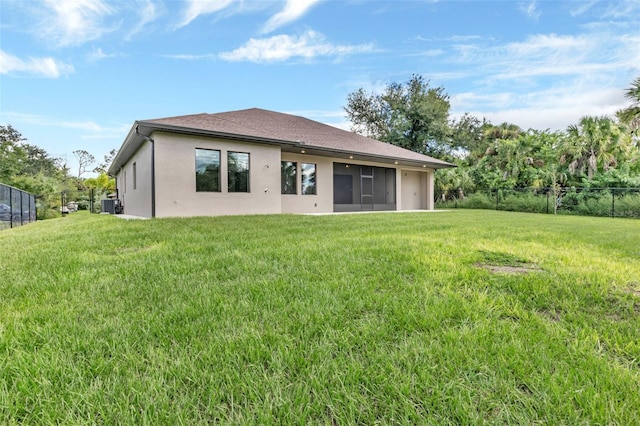 back of property with a lawn, roof with shingles, fence, central AC, and stucco siding