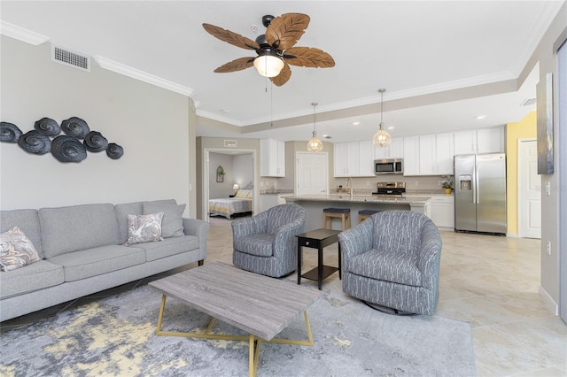 living room with ornamental molding, ceiling fan, light tile patterned floors, and sink