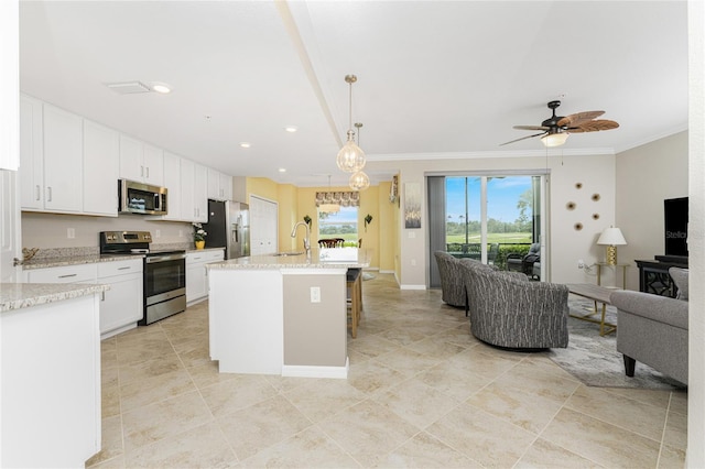 kitchen featuring pendant lighting, white cabinetry, stainless steel appliances, a center island with sink, and ceiling fan