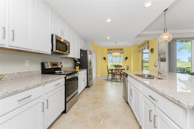 kitchen featuring white cabinets, stainless steel appliances, crown molding, and a wealth of natural light