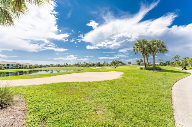 view of property's community featuring a lawn and a water view