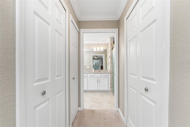 hall with light colored carpet, crown molding, and a chandelier