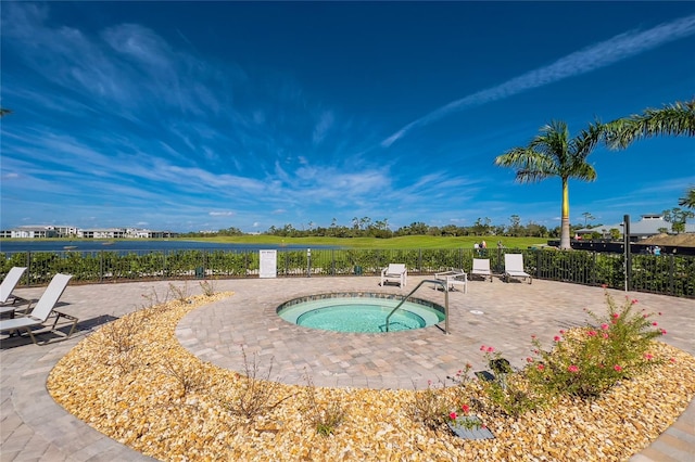 view of pool featuring a community hot tub, a water view, and a patio area