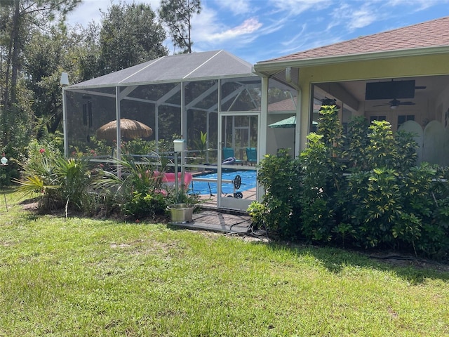 view of yard featuring ceiling fan and a lanai