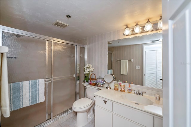 bathroom featuring walk in shower, vanity, toilet, and tile patterned floors