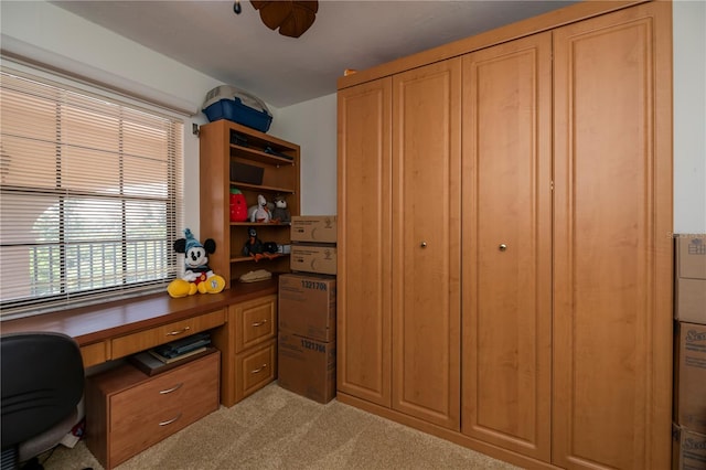 carpeted home office featuring ceiling fan