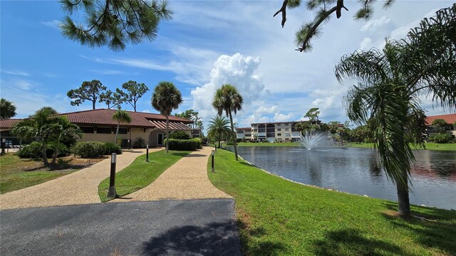 view of home's community featuring a lawn and a water view