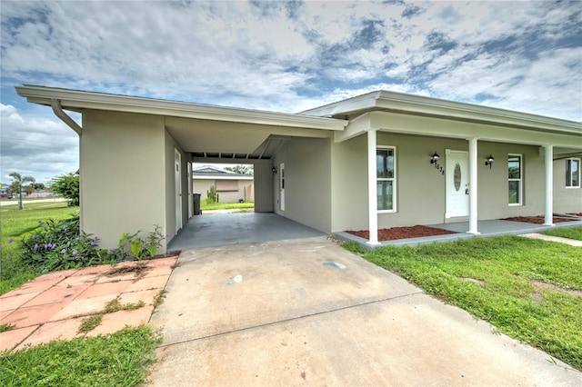 view of front of house featuring a carport, covered porch, and a front yard