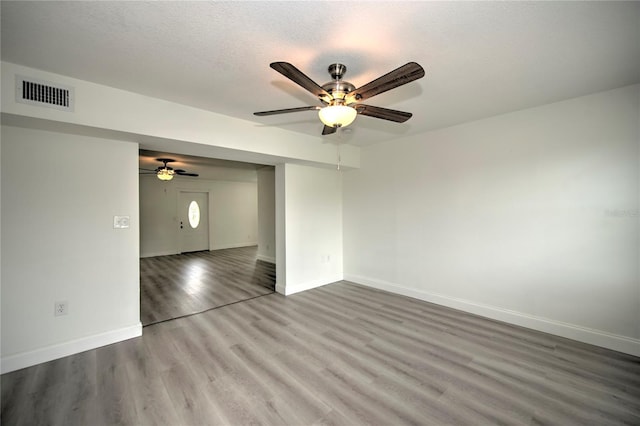 1638 Harmony Dr, Port Charlotte, FL 33952 - unfurnished room with a textured ceiling, visible vents, baseboards, wood finished floors, and a ceiling fan