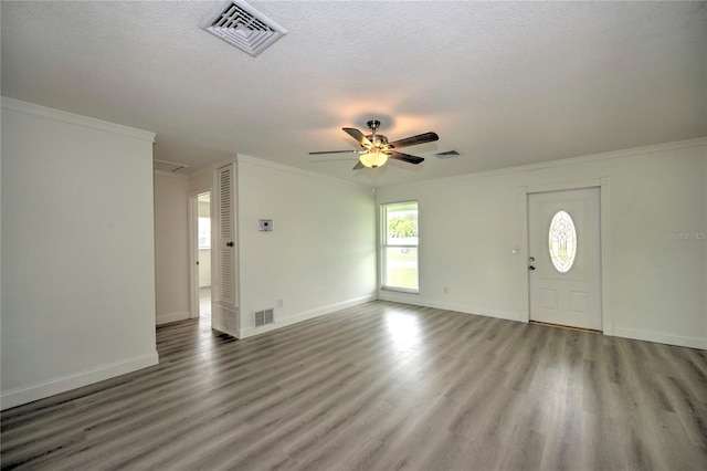 entryway with ornamental molding, wood-type flooring, ceiling fan, and a textured ceiling