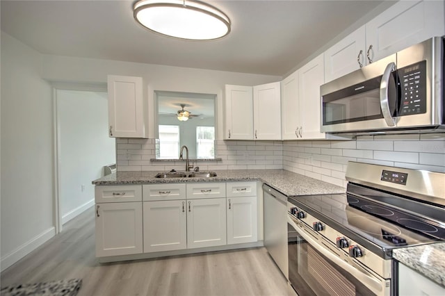1638 Harmony Dr, Port Charlotte, FL 33952 - kitchen with light wood-style flooring, white cabinetry, a sink, and stainless steel appliances