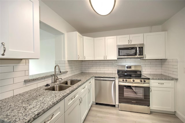 kitchen featuring light hardwood / wood-style flooring, appliances with stainless steel finishes, sink, and white cabinetry