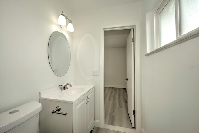 bathroom with hardwood / wood-style floors, vanity, and toilet