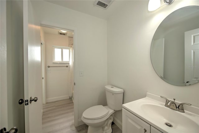 bathroom featuring wood-type flooring, vanity, and toilet