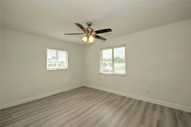 spare room with light hardwood / wood-style floors, ceiling fan, and a healthy amount of sunlight