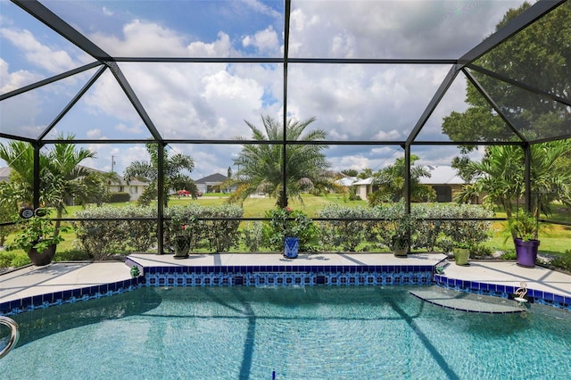 view of pool with glass enclosure and a patio area