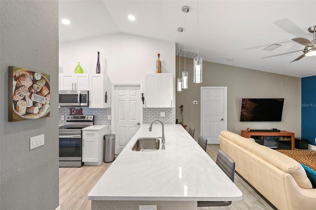 kitchen featuring ceiling fan, hanging light fixtures, sink, white cabinetry, and appliances with stainless steel finishes