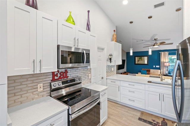 kitchen with appliances with stainless steel finishes, ceiling fan, pendant lighting, and white cabinets