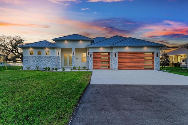 view of front of home with a yard and a garage