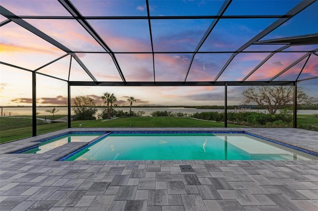 pool at dusk with a patio area, a lanai, and a water view