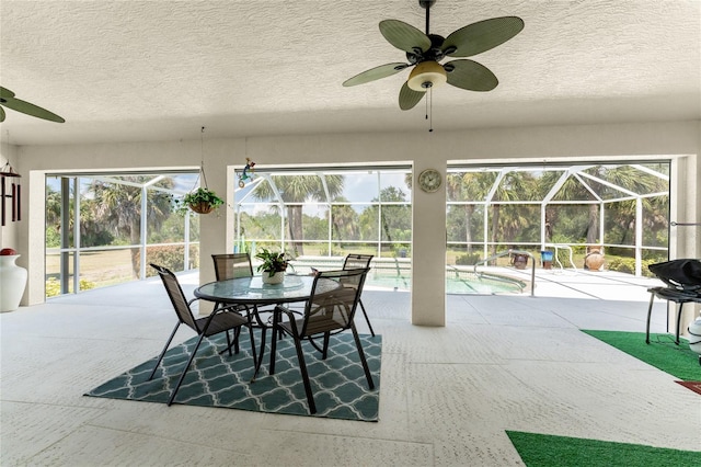 sunroom with ceiling fan, plenty of natural light, and a pool