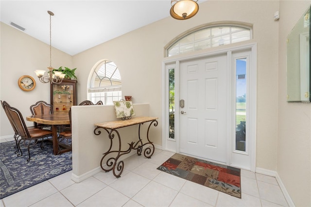 tiled entrance foyer with an inviting chandelier