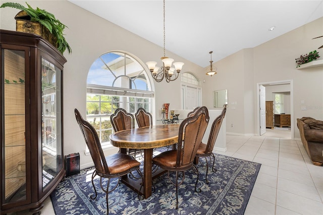 tiled dining area featuring high vaulted ceiling and a notable chandelier