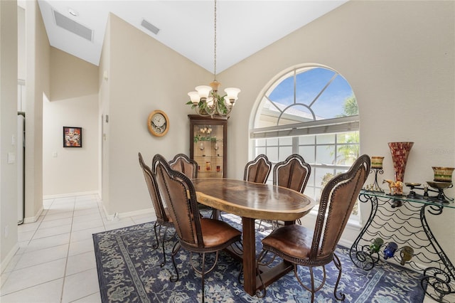 dining room with light tile patterned floors, high vaulted ceiling, and an inviting chandelier