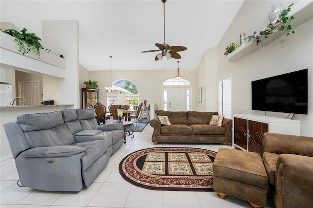 living room featuring ceiling fan with notable chandelier, light tile patterned floors, and high vaulted ceiling