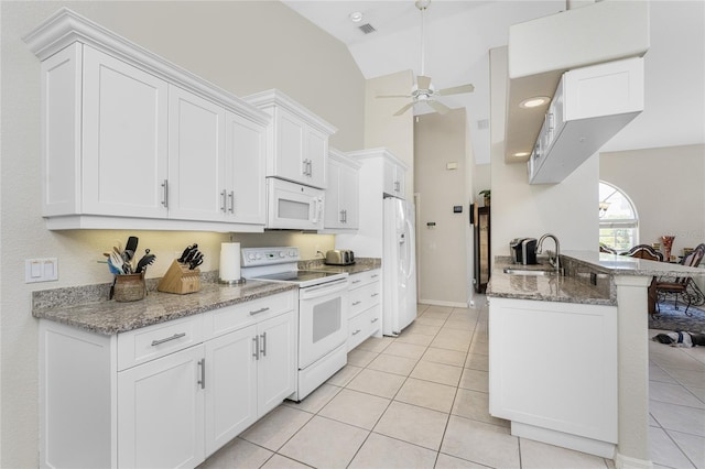 kitchen with white appliances, white cabinets, sink, dark stone countertops, and light tile patterned floors