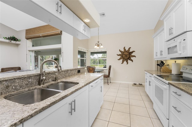 kitchen with white cabinets, light stone counters, white appliances, and sink