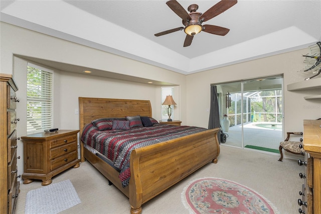 carpeted bedroom featuring access to outside, multiple windows, and ceiling fan