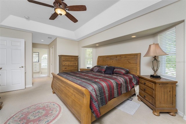 carpeted bedroom with ceiling fan and ensuite bath