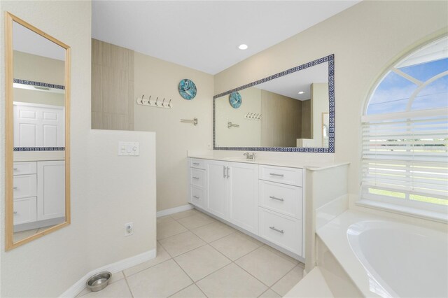 bathroom featuring tile patterned floors, a tub to relax in, and vanity