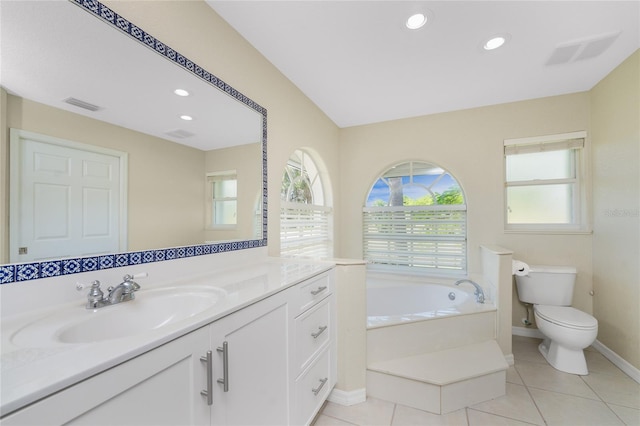 bathroom with tile patterned floors, vanity, toilet, and a tub