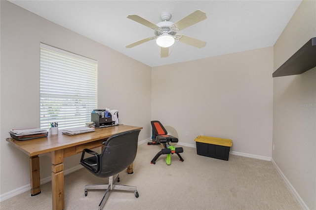 carpeted home office featuring ceiling fan