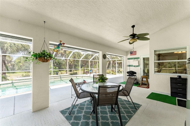 sunroom featuring ceiling fan, a pool, and lofted ceiling